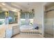 Charming bathroom featuring a garden tub, a vanity with mirror, and a walk-in shower at 1307 Highland Greens Dr, Venice, FL 34285