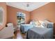 Bright bedroom with two twin beds, wicker furniture, and a view of lush landscaping at 1307 Highland Greens Dr, Venice, FL 34285