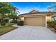 Exterior shot of a well-maintained home showcasing a garage, paved driveway, and landscaped front yard at 1307 Highland Greens Dr, Venice, FL 34285