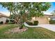 Lush front yard with mature landscaping, stone-edged flowerbeds, and concrete walkway leading to the entrance at 1307 Highland Greens Dr, Venice, FL 34285