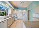 Bright kitchen with white cabinets, tile floors, and a granite countertop at 1307 Highland Greens Dr, Venice, FL 34285