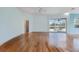 Spacious living room features wood floors, sliding doors leading to the lanai, and natural light at 1307 Highland Greens Dr, Venice, FL 34285
