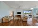 Inviting living room with hardwood floors, plush sofas, and access to an outdoor patio through sliding glass doors at 1307 Highland Greens Dr, Venice, FL 34285