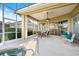 Relaxing screened-in patio with a ceiling fan, outdoor seating, and a soothing spa at 1307 Highland Greens Dr, Venice, FL 34285