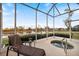 Relaxing screened-in patio with lake views, a lounger, and a hot tub for outdoor enjoyment at 1307 Highland Greens Dr, Venice, FL 34285