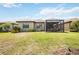 Well-manicured backyard featuring a screened-in patio, lush lawn, and beautiful landscaping at 13510 Esposito St, Venice, FL 34293
