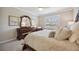 This bedroom boasts a ceiling fan, window, and a dresser with carved details at 13510 Esposito St, Venice, FL 34293
