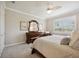 This bedroom boasts a ceiling fan, window, and a dresser with carved details at 13510 Esposito St, Venice, FL 34293