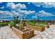 Community garden with planting beds, flowers and brick paver ground covering on a sunny day at 13510 Esposito St, Venice, FL 34293