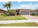 Beautiful one-story home with a lush landscaped yard and a two-car garage, set under a bright blue sky at 13510 Esposito St, Venice, FL 34293