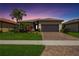 Beautiful single-story home features a well-manicured lawn and a brick driveway leading to an attached two-car garage at 13510 Esposito St, Venice, FL 34293