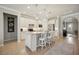 Kitchen features white cabinetry, stainless appliances, tile backsplash, granite countertops and island with barstool seating at 13510 Esposito St, Venice, FL 34293