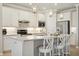 Bright kitchen features white cabinetry, stainless appliances, tile backsplash, granite countertops and island with barstool seating at 13510 Esposito St, Venice, FL 34293