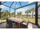 Outdoor patio seating area offers a picturesque view of the lush landscaping and serene lake at 13510 Esposito St, Venice, FL 34293