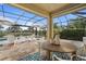 Covered patio with pool, table and chairs, and water view at 13807 Karina St, Venice, FL 34293