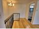 Upstairs hallway with hardwood floors and a view of a bathroom at 1640 Lemon Bay Dr, Venice, FL 34293