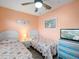 Guest bedroom with two twin beds, ceiling fan, and beach-themed decor at 2081 Willow Hammock Cir # F204, Punta Gorda, FL 33983