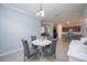 Dining room features a round table and four gray chairs, with view of kitchen at 24076 Spartina Dr, Venice, FL 34293