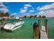 Boat docked at a pier, with calm green water and lush greenery at 287 Cassano Dr, Nokomis, FL 34275