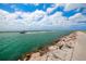 Motorboat traveling through inlet with rocky shoreline and blue sky at 287 Cassano Dr, Nokomis, FL 34275