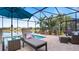 Screened patio with lounge chairs near pool and lake at 287 Cassano Dr, Nokomis, FL 34275