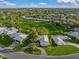 An aerial shot of a single-story home situated in a neighborhood with lush green spaces at 3305 Village Green Dr, Sarasota, FL 34239