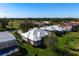 Aerial view of a house with white roof and pool, located in a golf course community at 515 Governors Green Dr, Venice, FL 34293