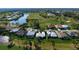 Aerial view of a house with a white roof near a golf course and pond at 515 Governors Green Dr, Venice, FL 34293