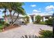 White house with teal front door, palm trees, and a large driveway at 515 Governors Green Dr, Venice, FL 34293