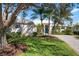 House exterior showcasing a teal door, palm trees, and a well-manicured lawn at 515 Governors Green Dr, Venice, FL 34293