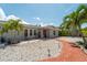 Beautiful front yard with brick walkway, well-kept landscaping, and rocking chairs on the front porch at 922 Casey Cove Dr, Nokomis, FL 34275