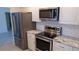 Kitchen with stainless steel appliances, white cabinets, and granite countertops at 922 Casey Cove Dr, Nokomis, FL 34275