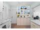 Kitchen featuring white shaker cabinets, stainless steel appliances, and glass front display cabinets at 922 Casey Cove Dr, Nokomis, FL 34275