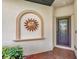 Home entrance featuring a brick walkway, mosaic sun decor, and screened front door at 9855 Haze Dr, Venice, FL 34292