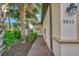 Home exterior featuring a brick walkway with tropical trees and lush greenery at 9855 Haze Dr, Venice, FL 34292