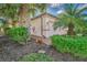 Well-maintained home exterior featuring a two-car garage and tropical landscaping at 9855 Haze Dr, Venice, FL 34292