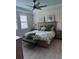 Light-filled bedroom with ceiling fan, tray ceiling, and peaceful views from the windows at 10055 Crooked Creek Dr # 102, Venice, FL 34293
