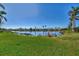 Scenic backyard view with a serene lake, lush greenery, and clear blue skies creating a peaceful retreat at 11679 Anhinga Ave, Venice, FL 34292