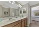 Double vanity bathroom with light wood cabinets and a large mirror at 11679 Anhinga Ave, Venice, FL 34292