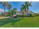 Well-manicured front yard with mature landscaping, lush lawn, and a charming paver driveway leading to the home at 11679 Anhinga Ave, Venice, FL 34292