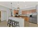 Stylish kitchen featuring stainless steel appliances, granite countertops, breakfast bar with pendant lights at 11679 Anhinga Ave, Venice, FL 34292