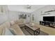 Living room with large sectional sofa, TV and backyard views through window at 11679 Anhinga Ave, Venice, FL 34292