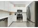 Modern kitchen with stainless steel appliances and white cabinetry at 12313 Amica Loop, Venice, FL 34293