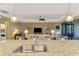 Kitchen island with sink, granite countertops, and view into living room at 13722 Vancanza Drive, Venice, FL 34293