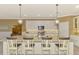 Bright kitchen boasts white cabinets, granite island, and stainless steel appliances at 13722 Vancanza Drive, Venice, FL 34293