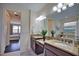 Double vanity bathroom with granite countertop and view to bedroom at 140 Maraviya Blvd, Nokomis, FL 34275