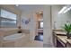 Bathroom with soaking tub, granite vanity, and bedroom access at 140 Maraviya Blvd, Nokomis, FL 34275