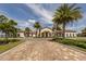 Community clubhouse with palm trees and brick driveway at 140 Maraviya Blvd, Nokomis, FL 34275
