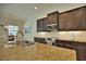 Gourmet kitchen with granite countertops, stainless steel appliances, and dark wood cabinets at 140 Maraviya Blvd, Nokomis, FL 34275