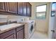 Bright laundry room, washer, dryer, cabinets, and sink at 140 Maraviya Blvd, Nokomis, FL 34275